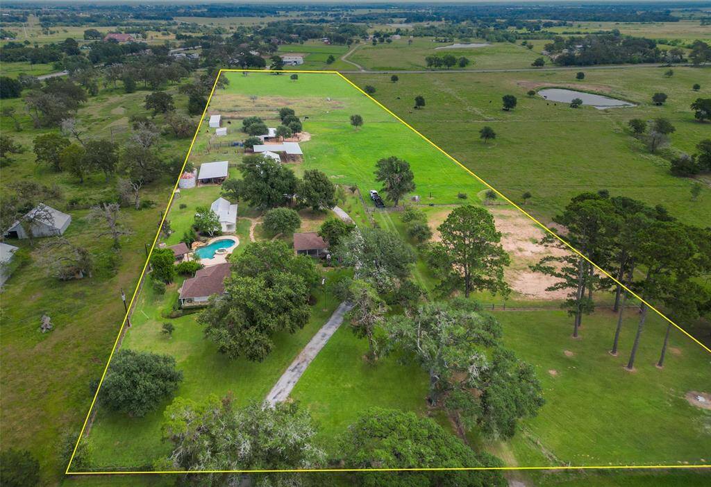 Breathtaking aerial view of the ~12-acre lease property, featuring wide-open pastures, equestrian amenities, and a well-planned layout with privacy and space to roam.