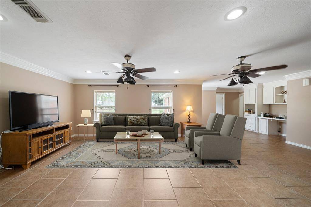 Spacious living area virtually staged to show its full potential — plenty of room to relax, entertain, or gather around the cozy wood-burning stove.