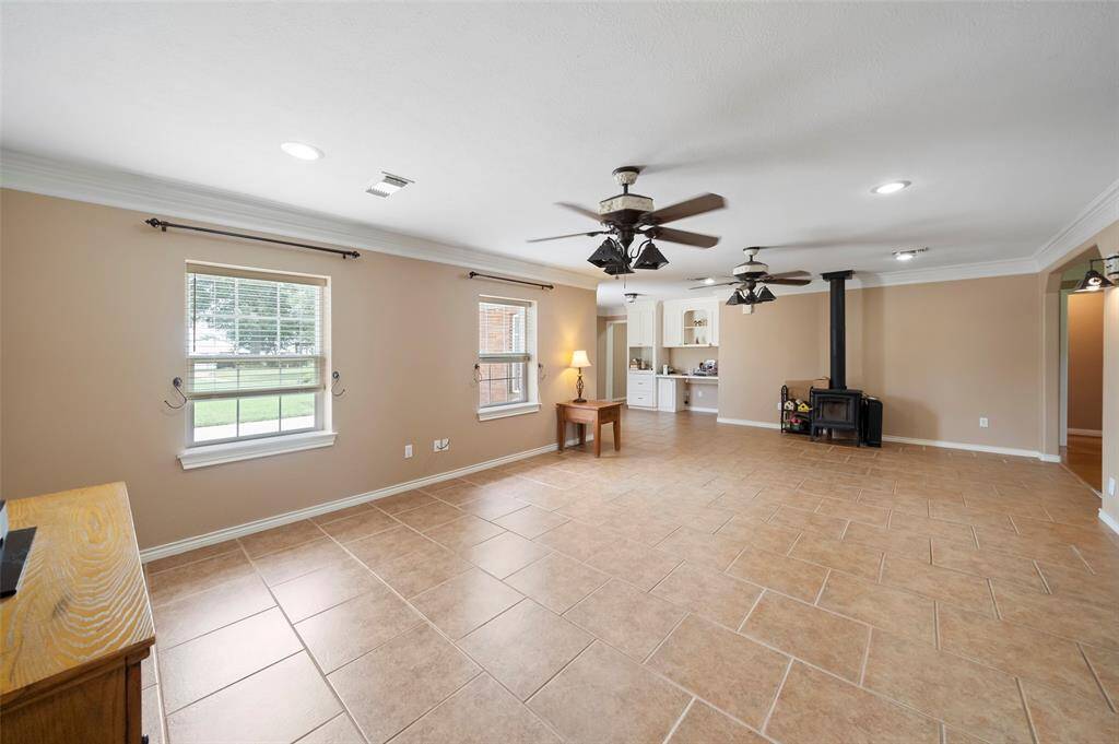 Open-concept living with plenty of space to spread out—tile floors, crown molding, and a Soapstone wood-burning stove add comfort and charm.