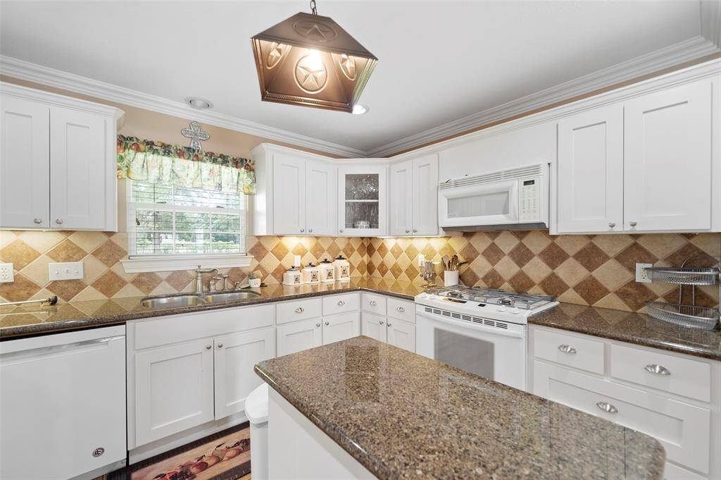 A closer look at the beautifully finished kitchen, complete with under-cabinet lighting, tile backsplash, and generous prep space.