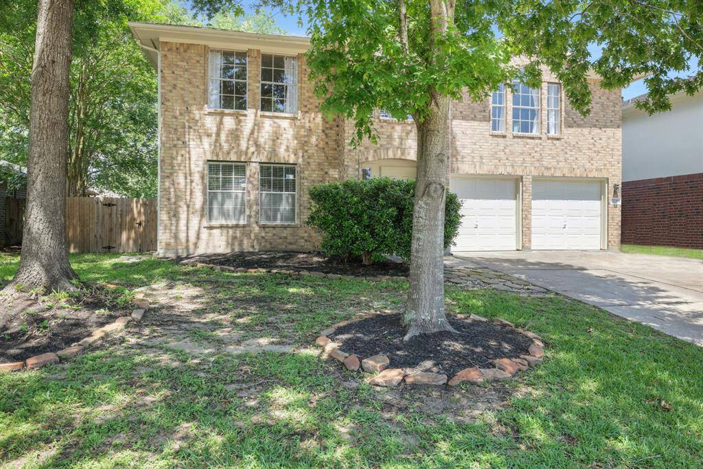 This charming two-story brick home features a double garage, mature trees, and a well-maintained front yard. The large windows offer plenty of natural light, and the driveway provides ample parking space.