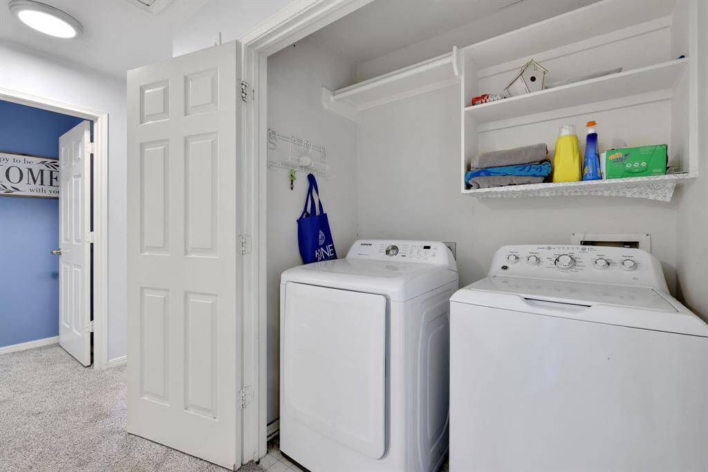 Compact Laundry room with a washer and dryer, built-in shelving for storage, The space is bright and is conveniently located in hall of the side with the four bedrooms.