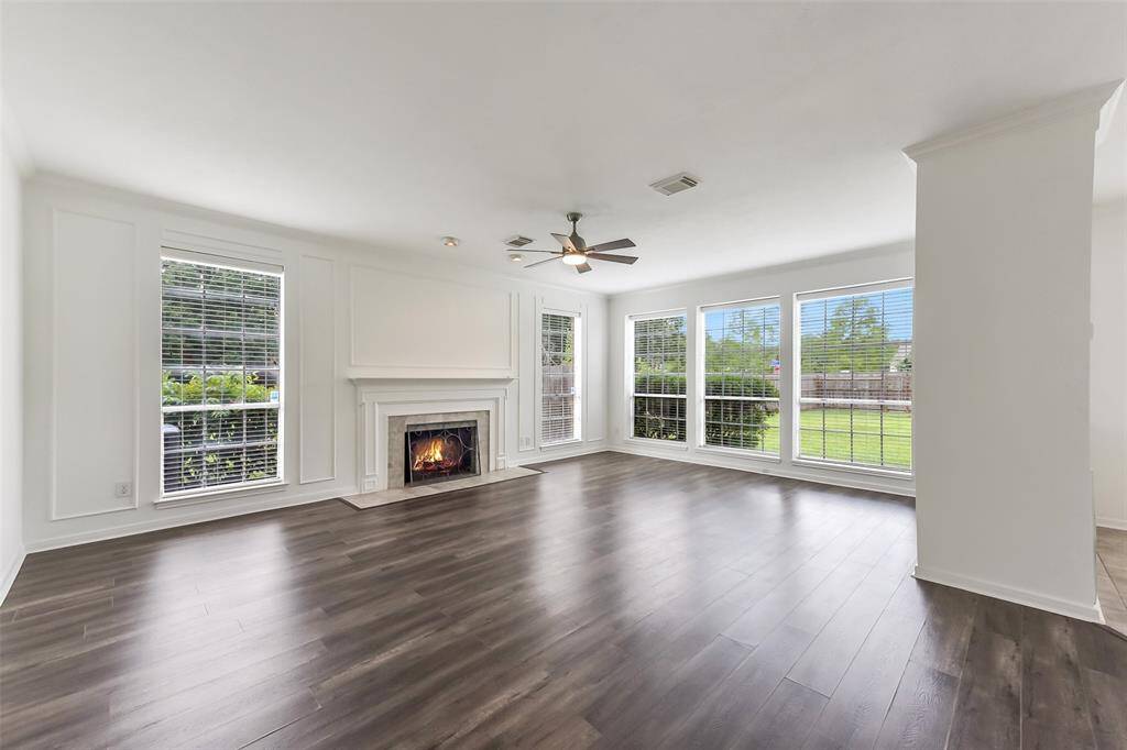 BRIGHT AND OPEN FAMILY ROOM OFFERS CAN LIGHTING, NEUTRAL PAINT, AND BUILT-IN STORAGE.