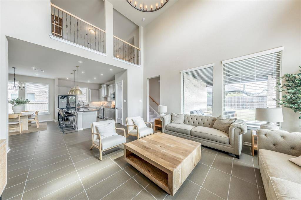 Expansive family room with soaring ceilings, abundant natural light, and open views into the kitchen and dining area. A welcoming layout perfect for large get-togethers.