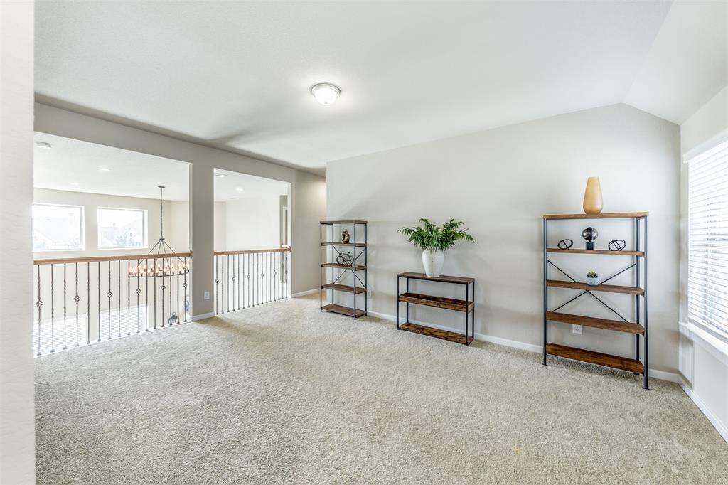 This spacious upstairs game room is the perfect place for a full size pool table and other fun activities! Plenty of room for a friends and family to gather for a night of games! Featuring a high angled ceiling, plush carpet for comfort and a view of the family room below!
