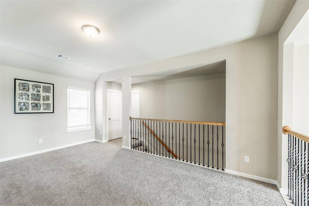 This spacious upstairs game room is the perfect place for a full size pool table and other fun activities! Plenty of room for a friends and family to gather for a night of games! Featuring a high angled ceiling, plush carpet for comfort and a view of the family room below!
