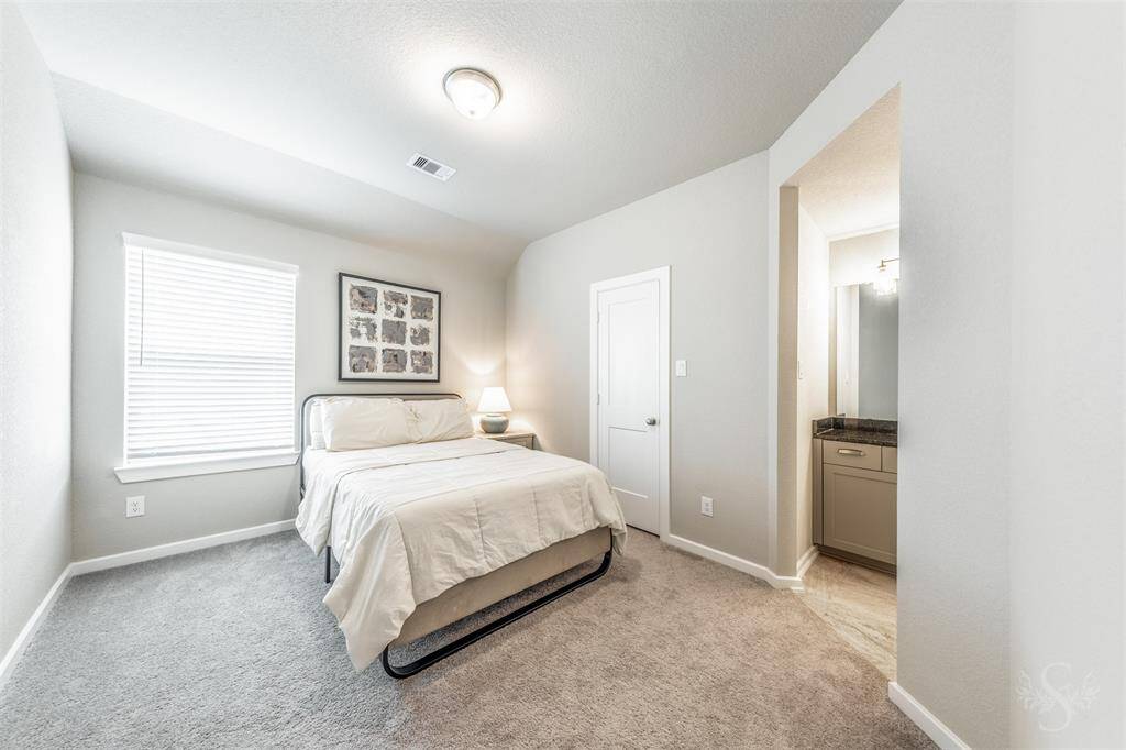 Comfortable secondary bedroom with neutral carpeting, high angled ceiling, walk-in closet and a private bath entrance. Large window brings in beautiful natural light, creating a cheerful and welcoming space.