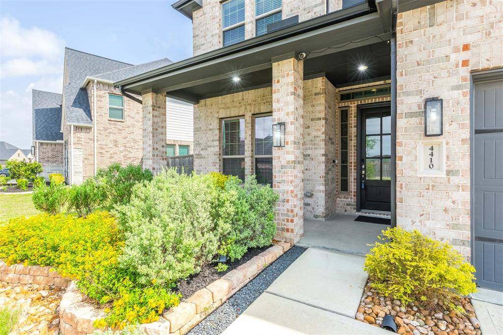 Inviting front porch framed by upgrade lush landscaping and brick columns that lead to a stylish glass-paneled front door. A warm and welcoming entry with recessed lighting sets the tone for the thoughtfully designed interior. Upgraded French drains installed.
