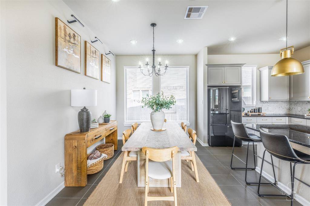 Spacious dining area filled with natural light, featuring tile flooring and a lovely new chandelier. Flows effortlessly into the gourmet kitchen, creating the ideal setting for family meals and entertaining.