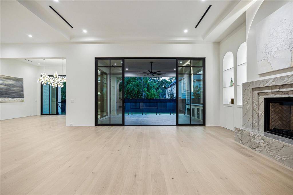 The porch railing has glass panel inserts which heighten the sense of depth across the sizeable yard.