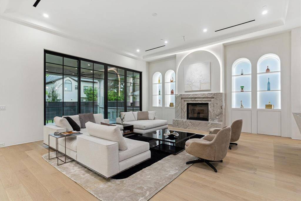 The Quartzite fireplace surround is balanced by thematic arches with internal lighting above and within the side windows to illuminate the display shelving.
