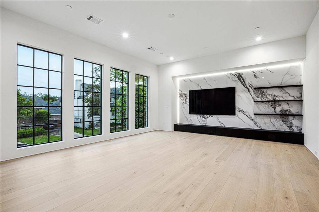 The central gathering spot for the family upstairs, the 22x17 Game Room features a inset wall of stone with perimeter lighting, floating shelves- complete with an 85 inch Samsung NEO QLED.