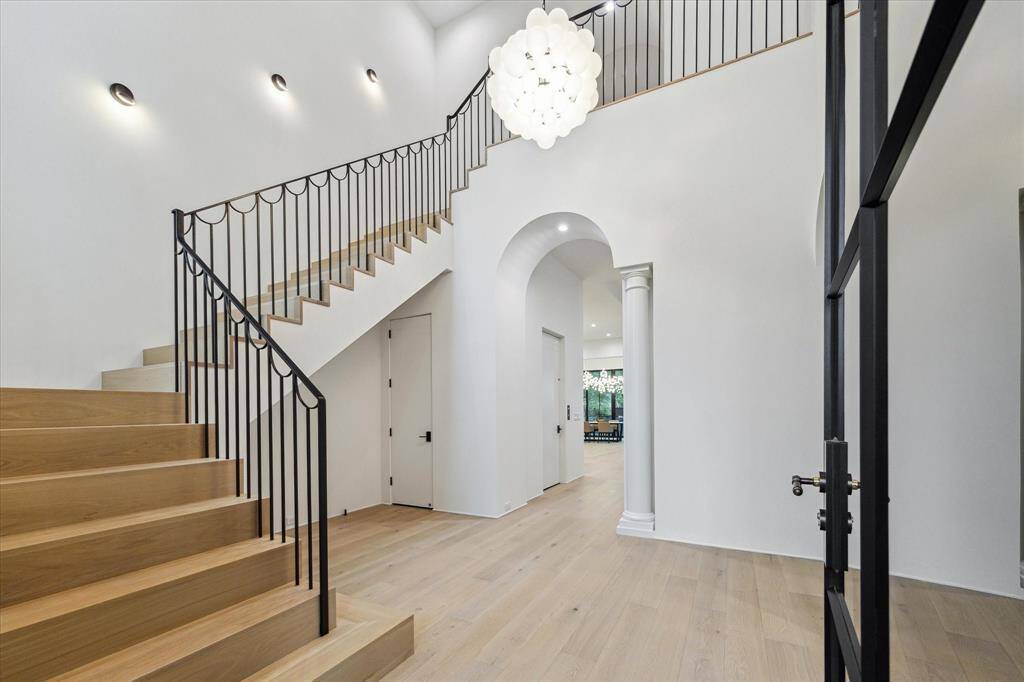 The stairway has solid white oak treads and risers in a waterfall style. The handrail is a wrought iron custom manufacture.