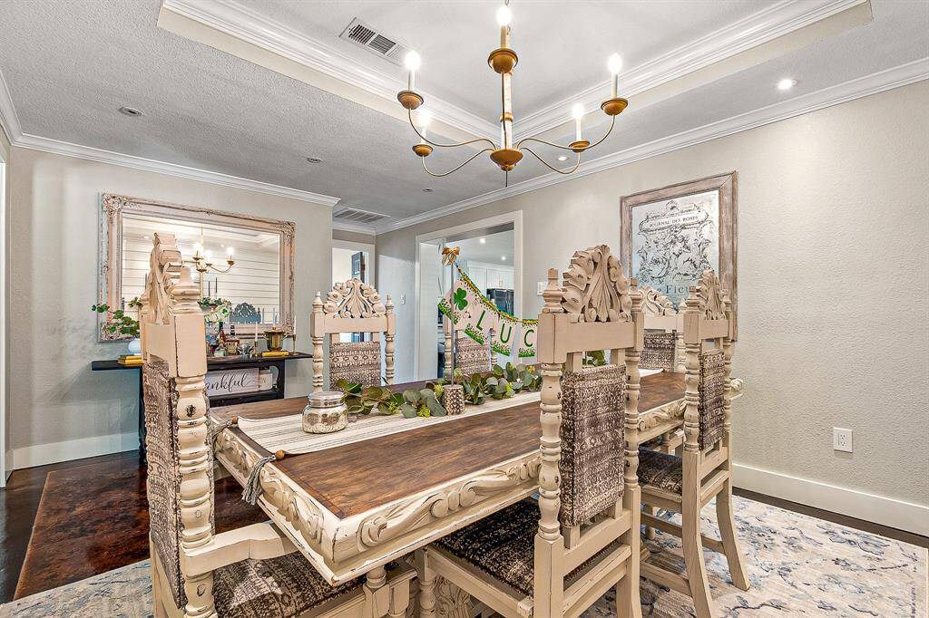 This dining room features a stylish chandelier that adds charm while neutral walls enhance the space's warmth and sophistication.