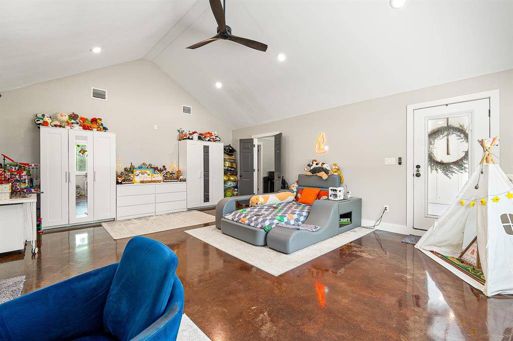 This spacious room features a high ceiling, polished floors, and ample natural light. Ideal for relaxation or play.
