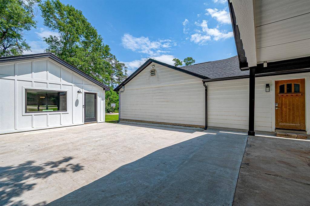 This photo showcases a spacious concrete driveway leading to the Guest house. The open area is ideal for parking or outdoor activities.