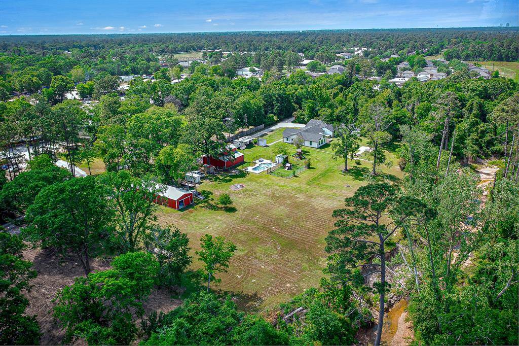 This aerial photo showcases the spacious property. The area is surrounded by lush trees, offering privacy and a natural setting.