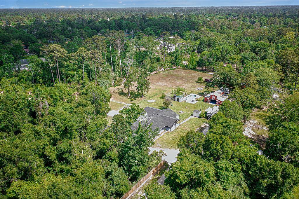 This aerial photo showcases the spacious property. The area is surrounded by lush trees, offering privacy and a natural setting.