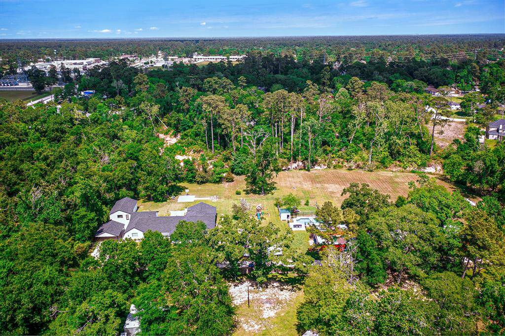 This aerial photo showcases the spacious property. The area is surrounded by lush trees, offering privacy and a natural setting.