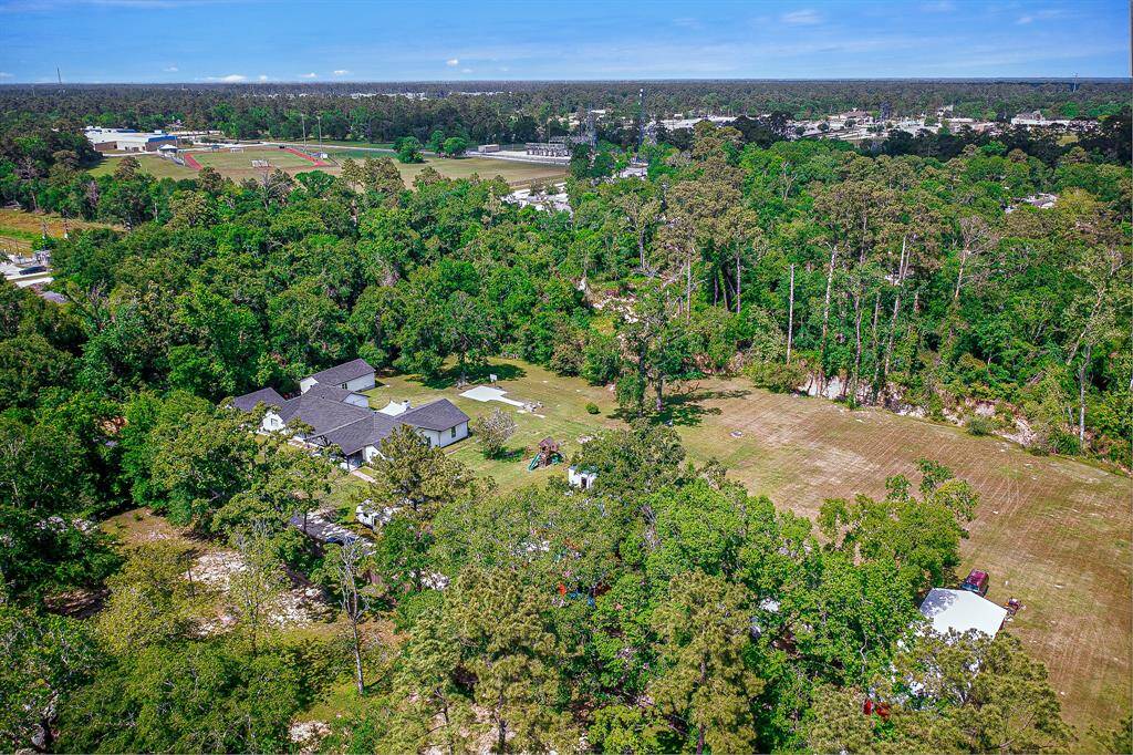 This aerial photo showcases the spacious property. The area is surrounded by lush trees, offering privacy and a natural setting.