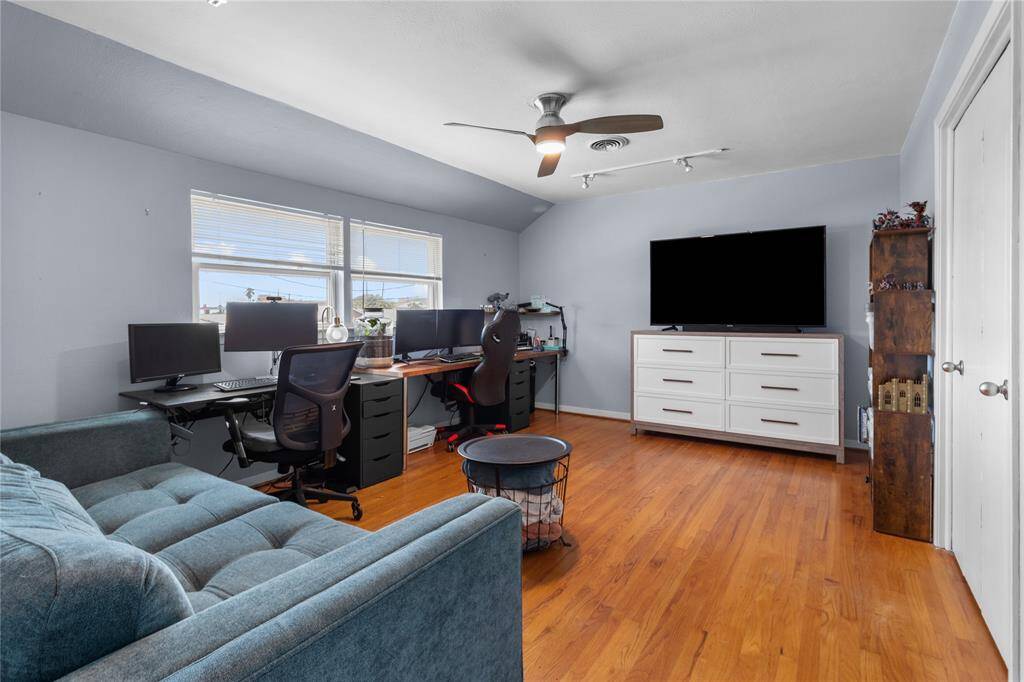 Bright and spacious home office (second floor bedroom) with hardwood floors, featuring light paint scheme and new ceiling fan. Ideal for productivity and relaxation.