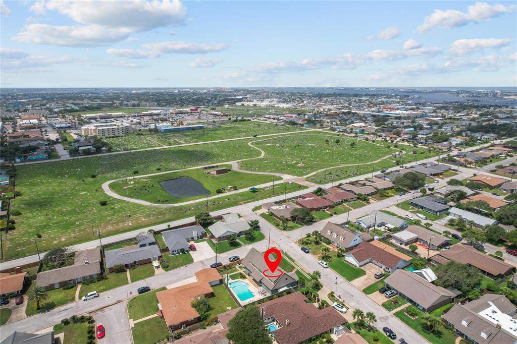 This aerial photo showcases a suburban neighborhood with a spacious layout. The highlighted home features a pool and is situated in an area that is well-maintained and offers convenient access to nearby amenities and a scenic view.