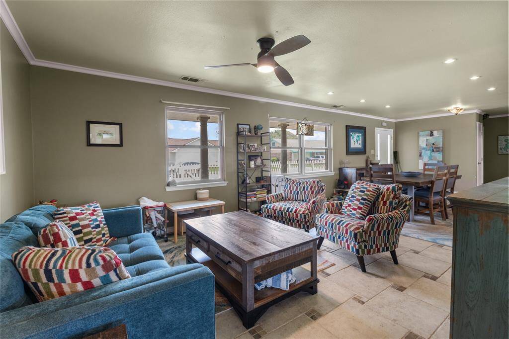 This inviting living and dining area features a cozy seating arrangement. Large windows provide ample natural light, while the open layout flows seamlessly into the dining space. The room is accented with warm tones and modern lighting.