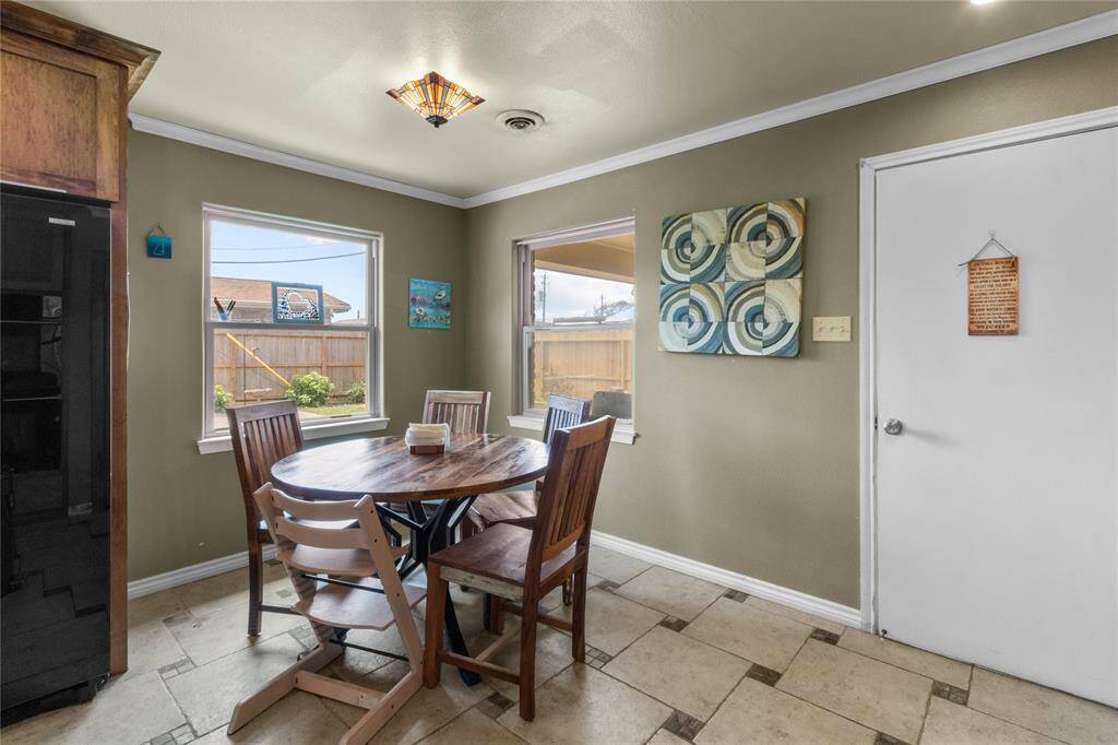 Cozy dining area with two windows for natural light, neutral green walls, and decorative lighting creating a welcoming atmosphere.