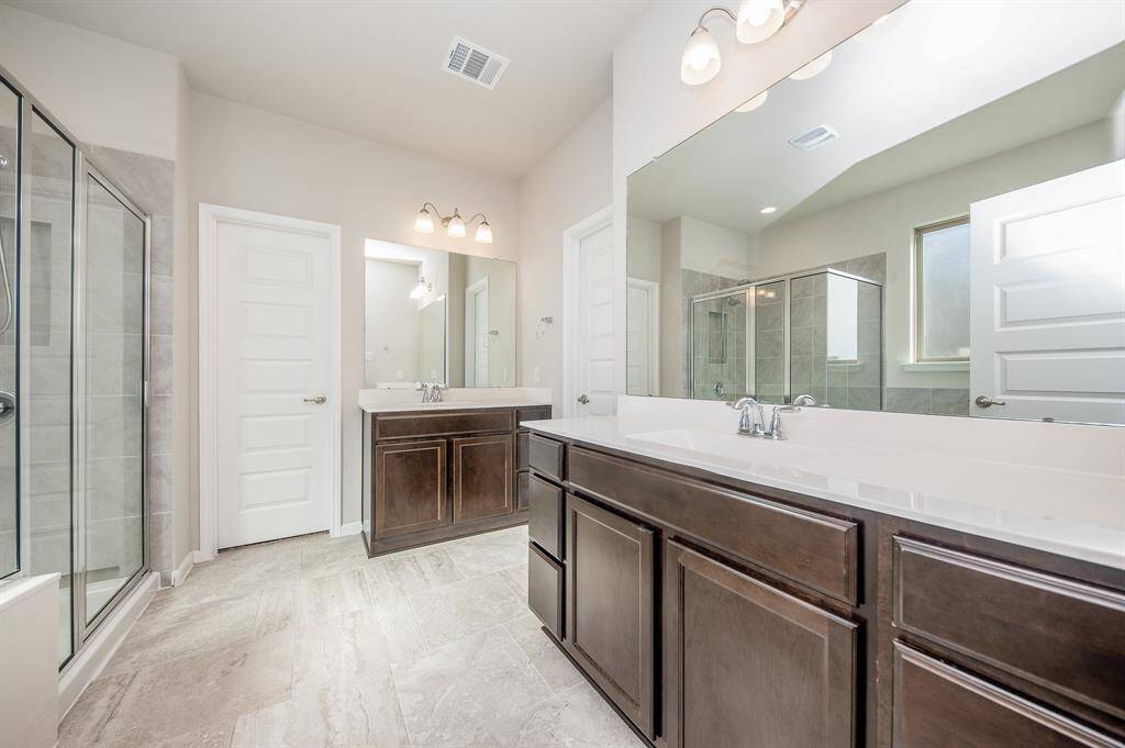 This primary bedroom has a large private bathroom attached. Noticed the double sinks.