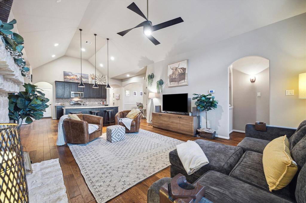 The handsome custom kitchen opens to the main living room, united by a gorgeous stone fireplace.