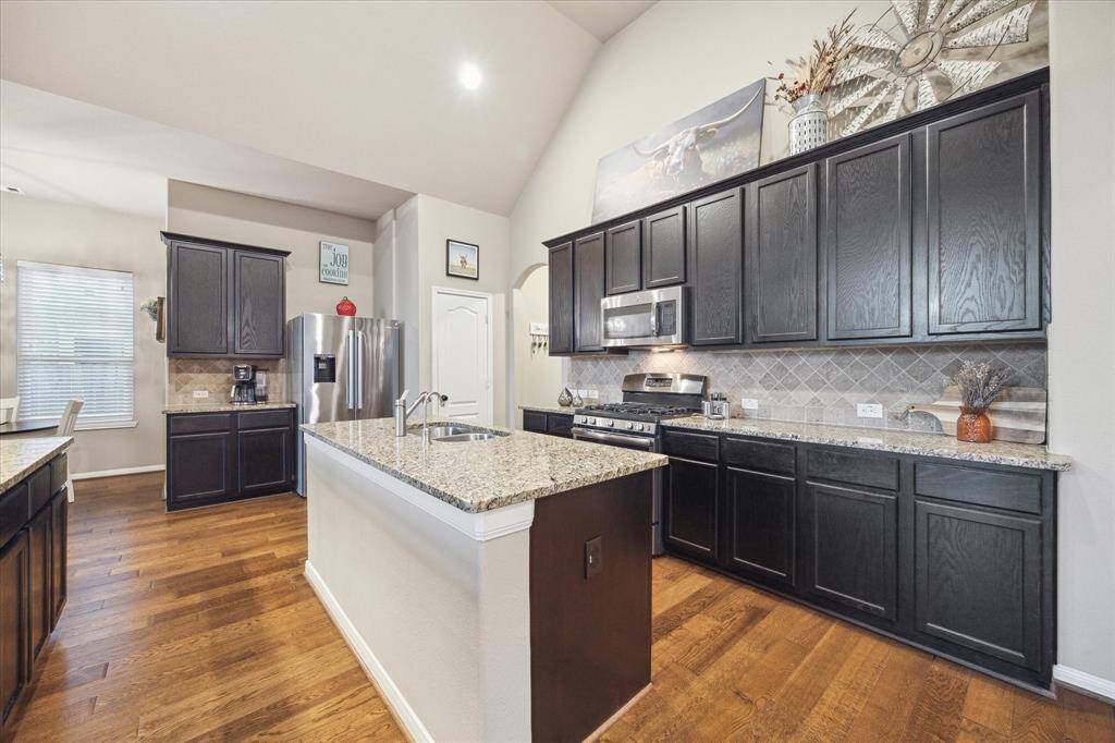 Dark coffee-colored wood kitchen cabinets accent the neutral earth-toned palette.