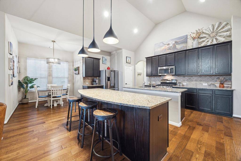 An open kitchen connected to defined spaces for dining like the eating nook and separate dining room offers flexibility and formality.