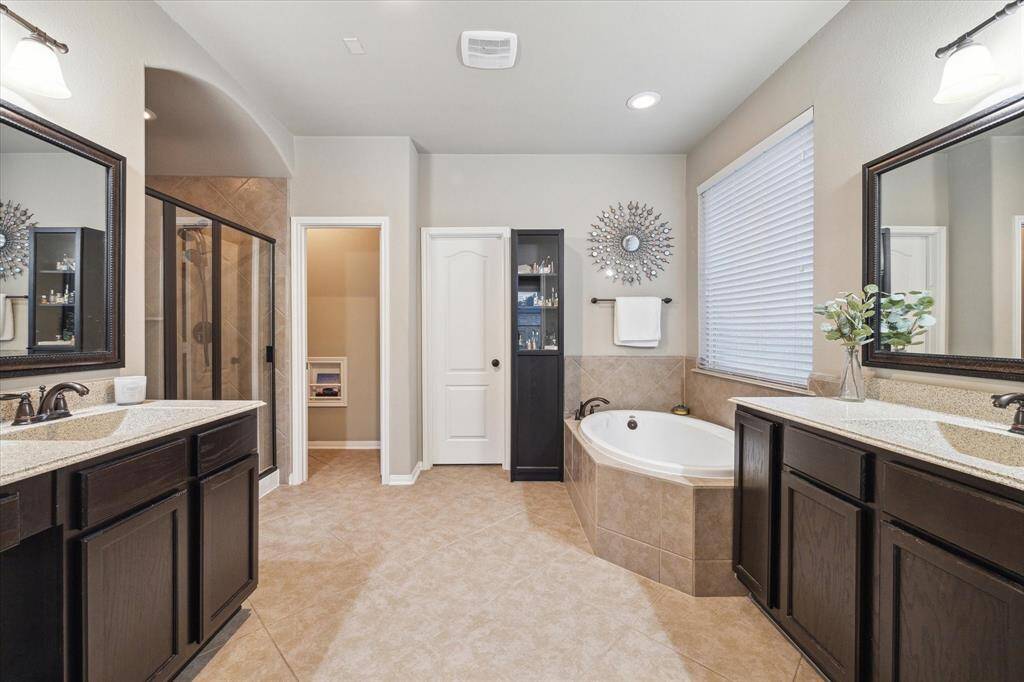 The primary en suite bathroom is well-designed with the much-desired dual vanities, separate walk-in shower and soaking tub.
