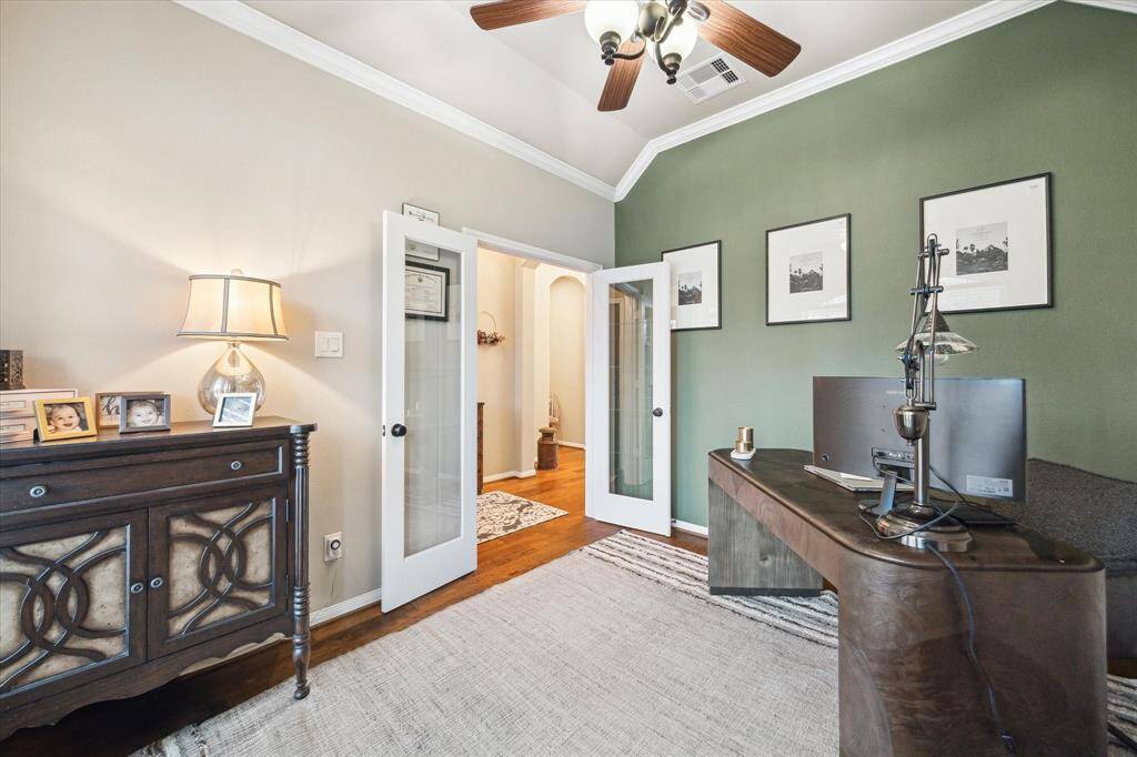 Glass French doors lead into the serene home office.
