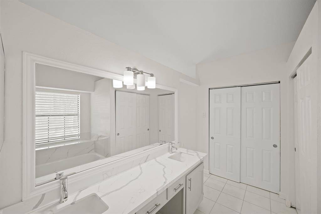 Primary Bathroom with garden tub and his / her sink
