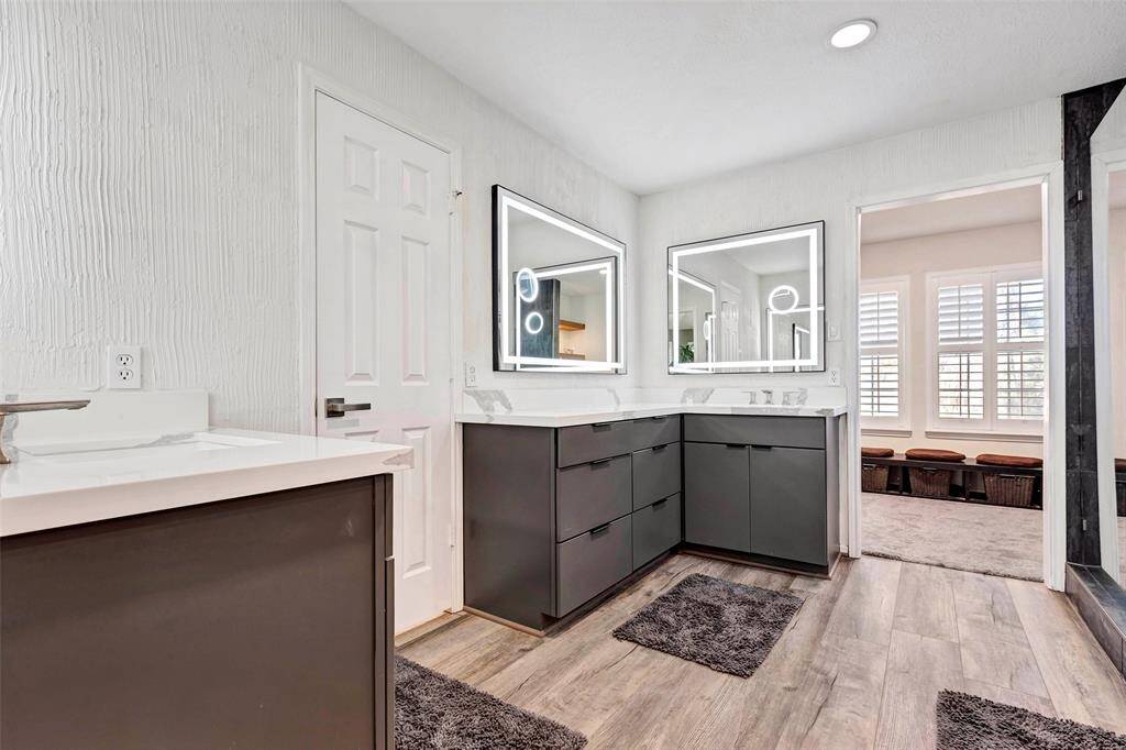 Elegant upgrades include modern cabinetry, sleek mirrors, updated countertops, and fresh paint.