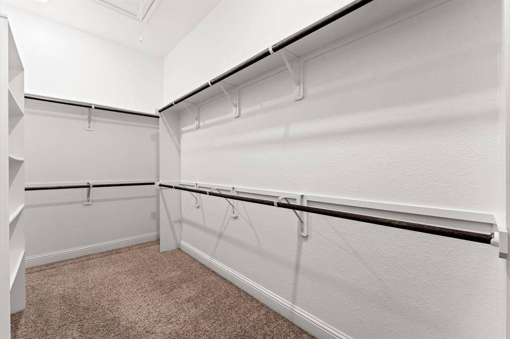 The spacious walk-in closet is a dream, with plenty of room to keep everything organized. Multiple hanging rods provide ample storage for all your wardrobe essentials.