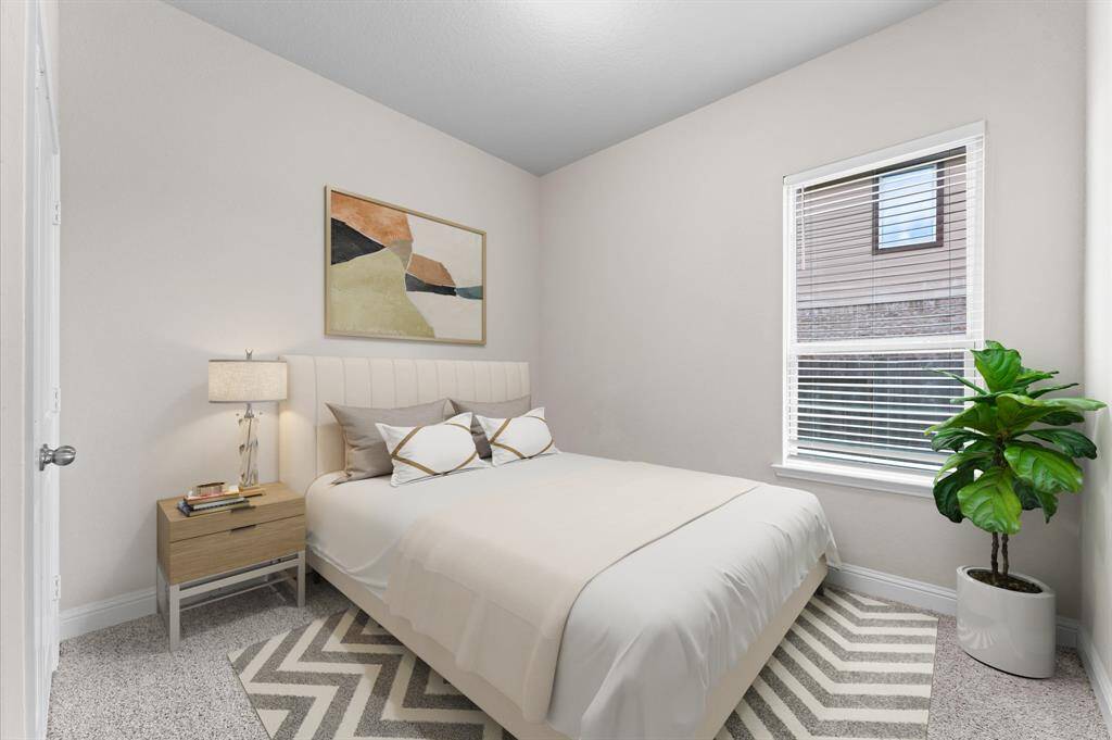 Designed for comfort and style, this fourth bedroom offers a warm and restful ambiance. Soft carpet flooring feels plush underfoot, complementing the bright, airy space.