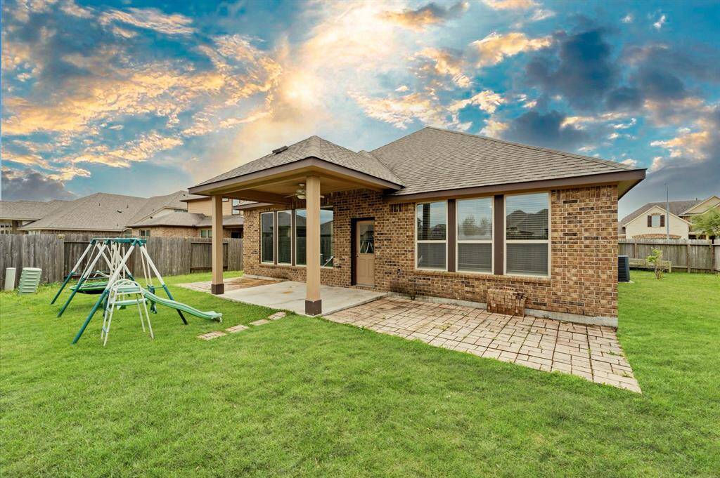 The spacious backyard features a dedicated children’s play area with a slide, swing, and trampoline.
