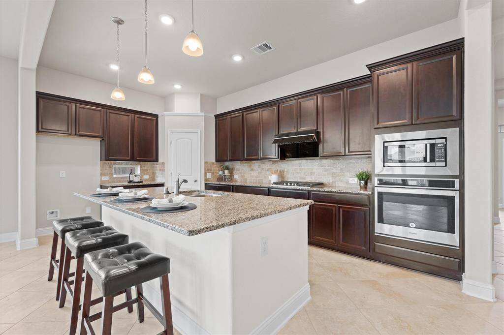 A grand island with pendant lighting invites casual dining and conversation.