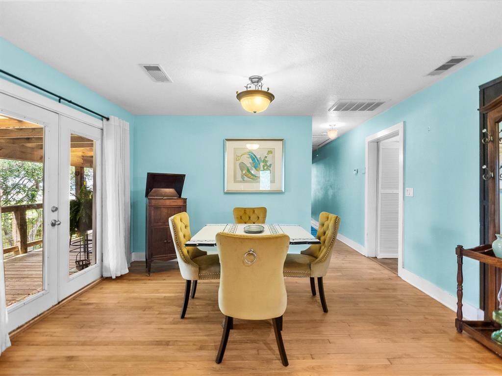 Bright dining area with large windows open to the wooden deck with sunset views.