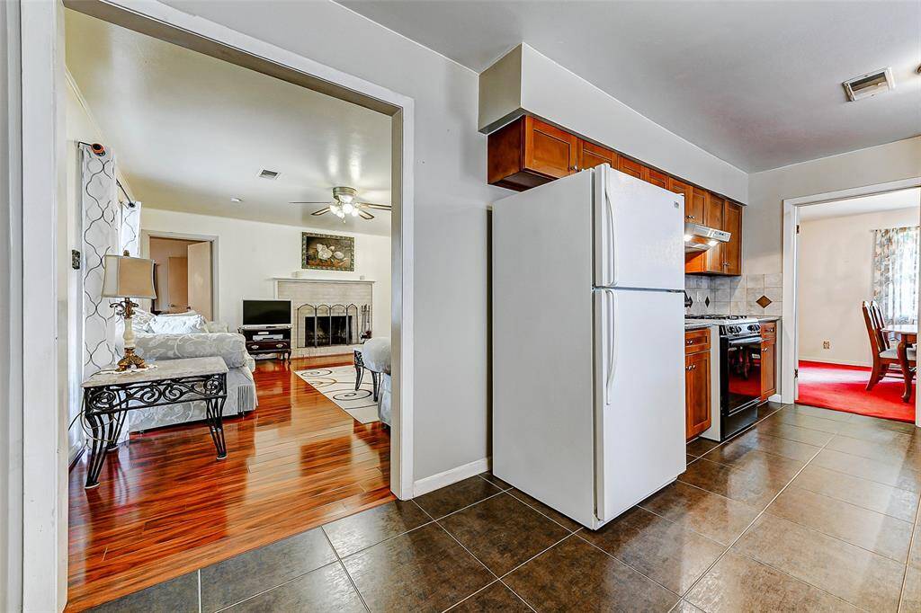 Seamlessly transition from the kitchen into the cozy living room featuring gleaming wood floors and a classic fireplace. Great for entertaining or enjoying relaxed evenings at home. An inviting floor plan ready for your personal touches!