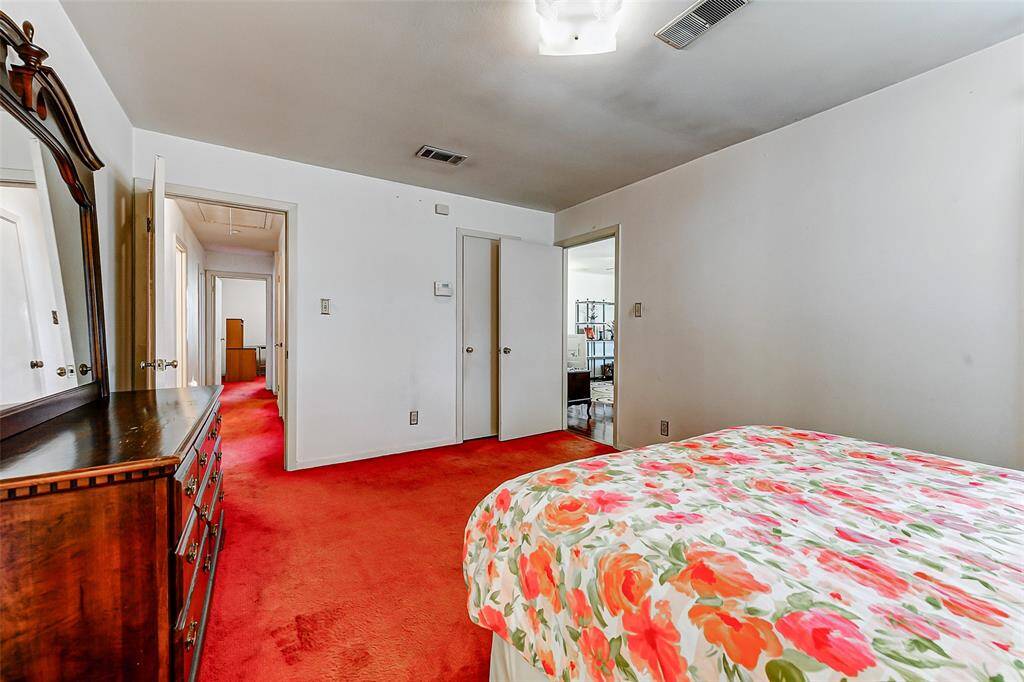 Spacious primary bedroom with easy access to the hallway and common areas. Classic layout offers privacy while maintaining a seamless connection to the rest of the home. Fresh natural light and warm vintage elements throughout.
