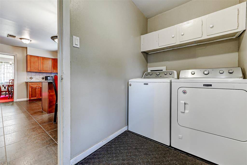 Bright and efficient, the laundry room is ideally located just off the kitchen and dining area. Equipped with built-in cabinetry for added storage, this space makes chores a breeze.