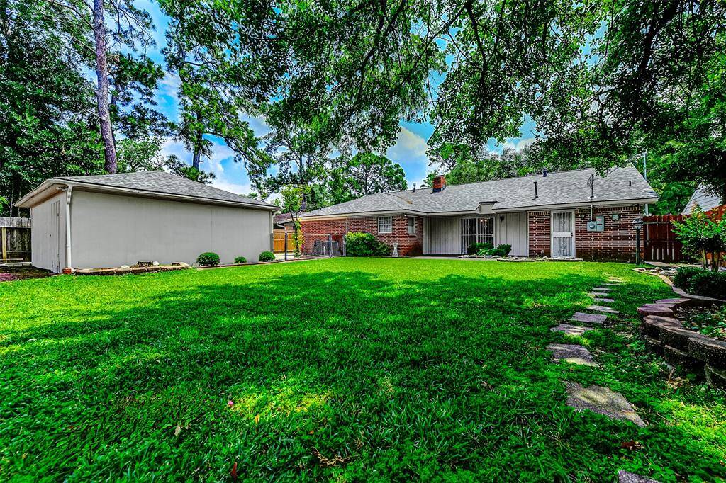 Sweeping view of the spacious backyard featuring mature trees, a detached garage, and a well-kept lawn. Perfect for weekend BBQs, gardening, or creating your very own backyard retreat.