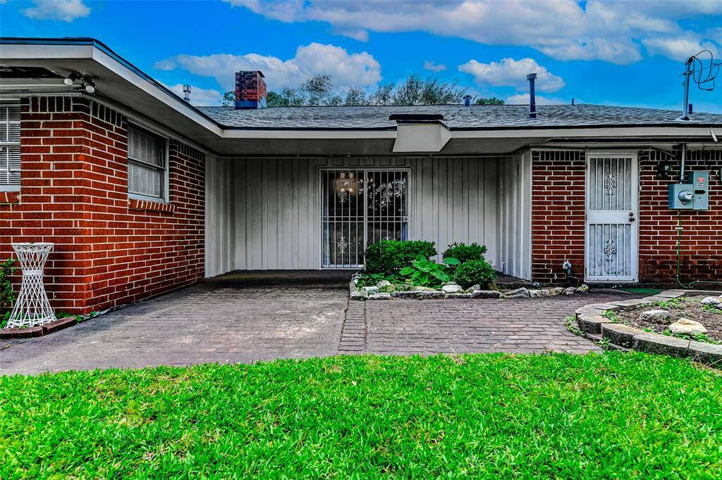 Relax and unwind under the covered patio, overlooking a beautifully landscaped backyard. Featuring a brick walkway, privacy fencing, and charming garden beds, this backyard invites everyday outdoor enjoyment.