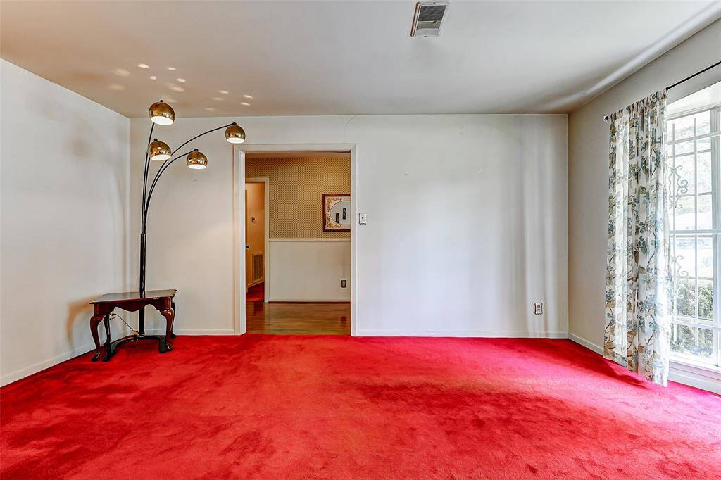 Bright and airy living space with a large bay window invites natural light to dance across vibrant flooring. Vintage touches and an open layout offer flexibility to create the perfect seating or entertainment area. Ready for your vision to shine!