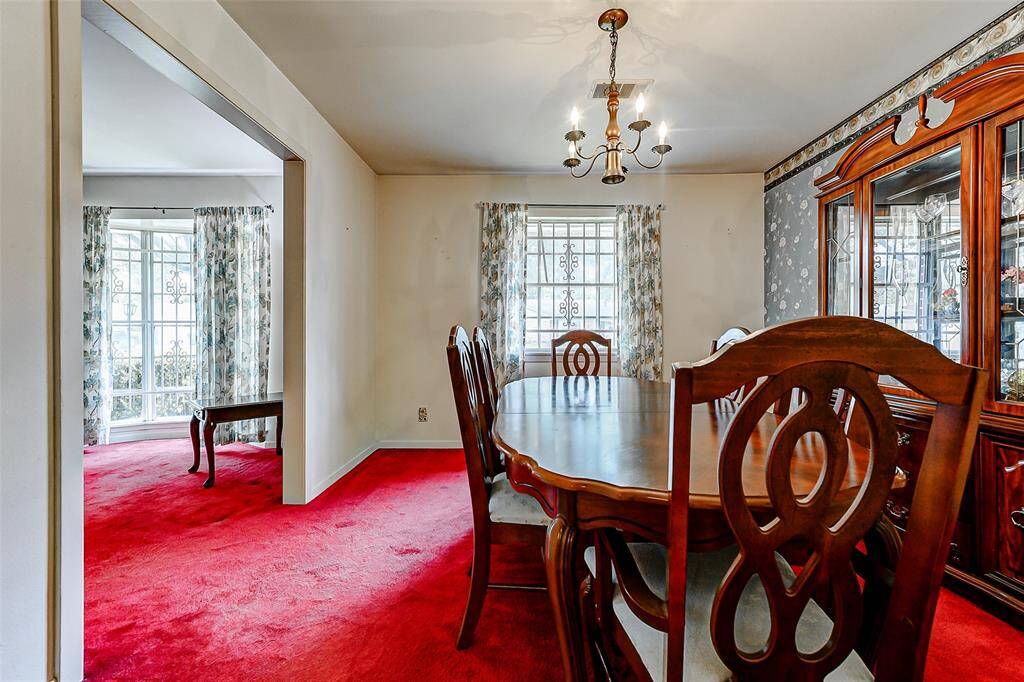 Flow seamlessly from dining to living in this traditional layout. Large windows bathe the space in natural light while timeless details like chair rail molding and vintage accents create a warm, welcoming feel.
