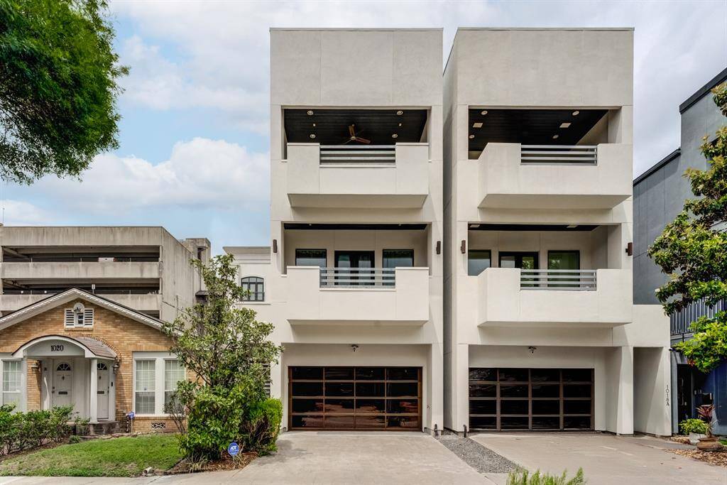 Modern duplex with a sleek, minimalist design featuring multiple balconies and large garage doors.