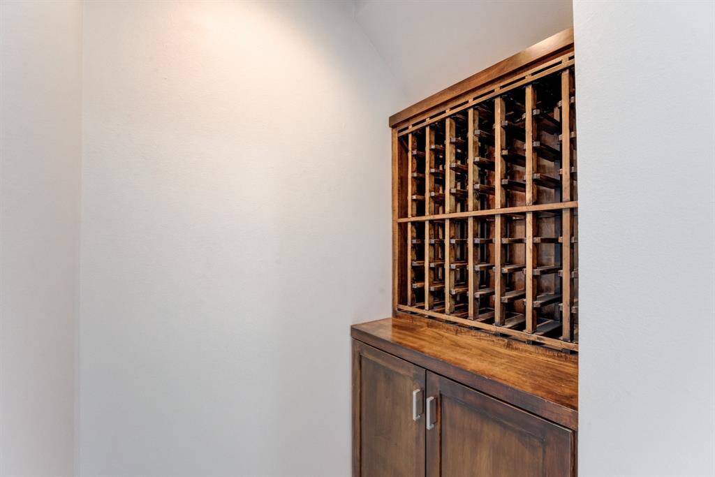 This photo shows a wooden wine rack with ample storage space, set in a nook with neutral walls, providing a stylish and functional feature for wine enthusiasts.
